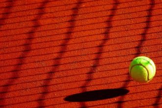 Balle de tennis et ombre du filet sur court en terre battue (Pixabay Anaïs Anaïs 29)