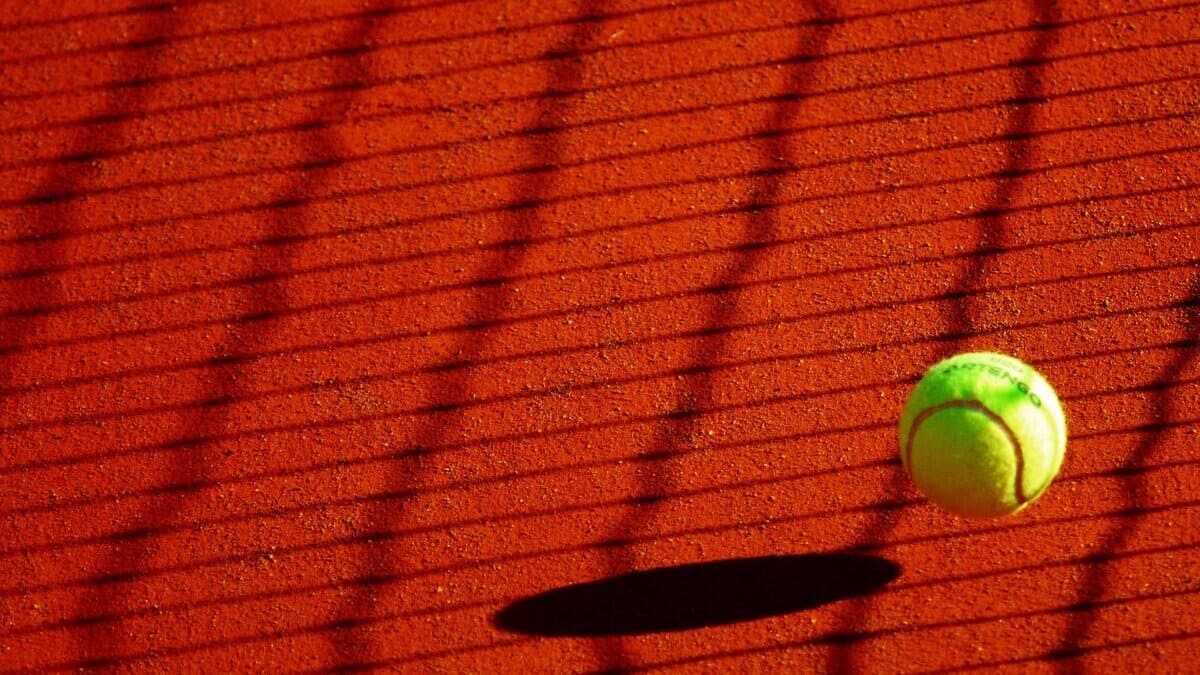 Balle de tennis et ombre du filet sur court en terre battue (Pixabay Anaïs Anaïs 29)